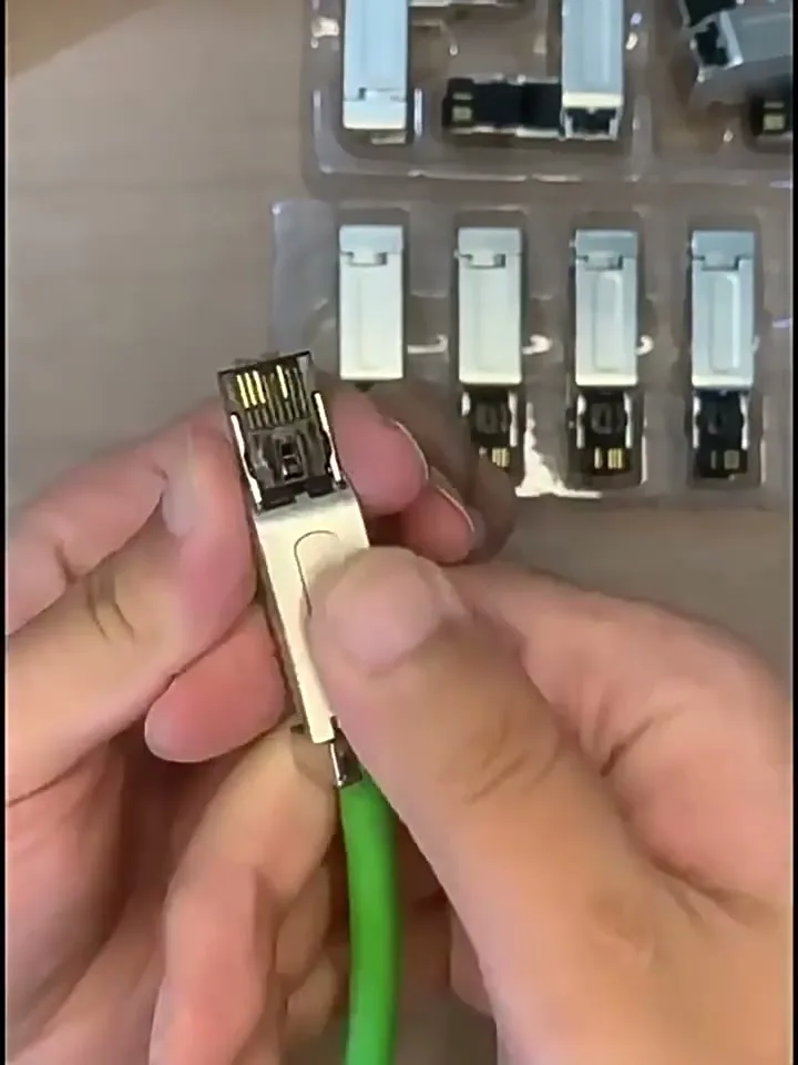 Pressing the hinged cover down until it latches over the conductors.